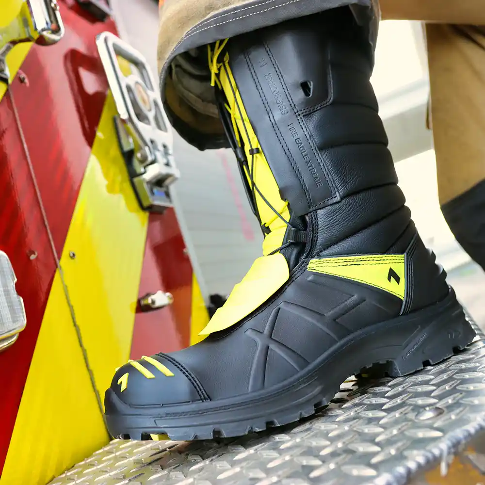 NFPA-certified Fire Eagle Xtreme firemen boots worn with turnout pants stepping on metal diamond plate step of fire truck.