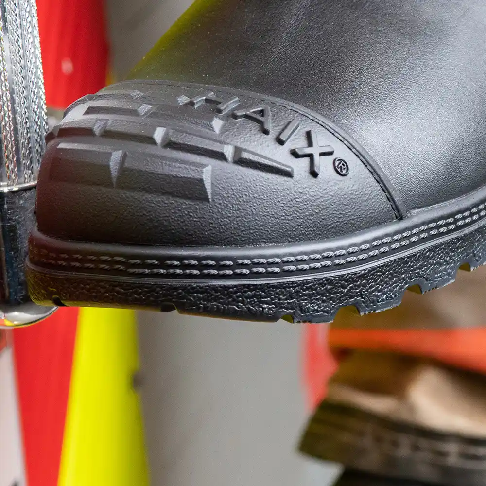Close-up on steel toe with profiled rubber exterior toe cap of black Fire Hunter USA bunker boots for max protection