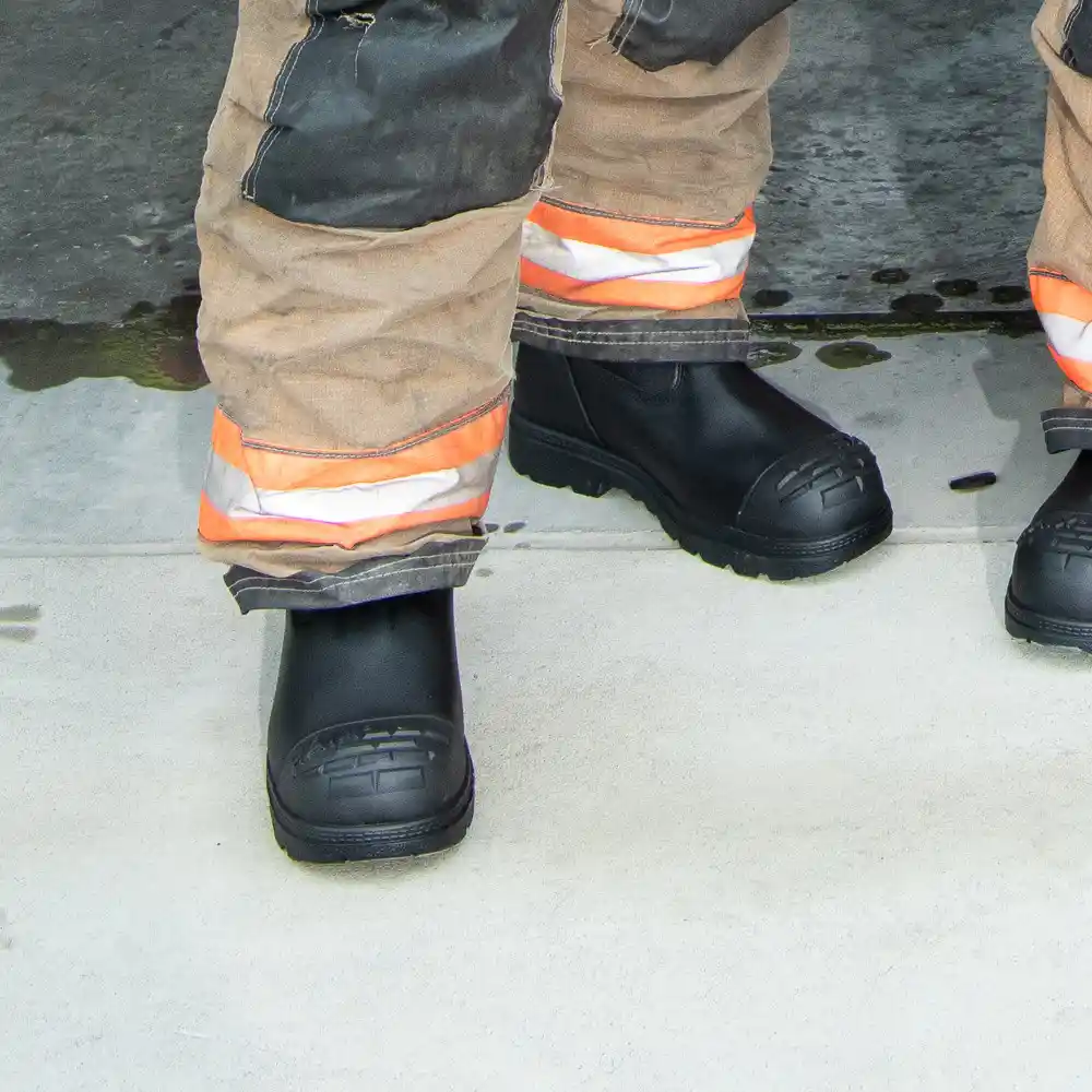 Black Fire Hunter USA HAIX boots worn with turnout pants on pavement, featuring CROSSTECH liner for waterproof protection