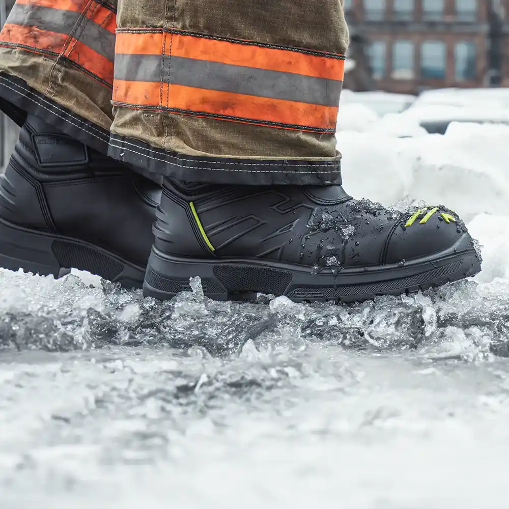 Close-up of NFPA-certified Fire Eagle Air Grip Xtreme fire boots worn with turnout pants moving through snow and slush.